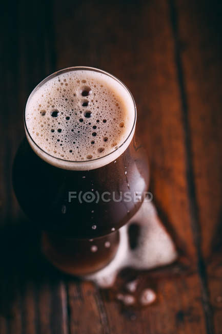 Stout beer in glass on dark wooden table — Stock Photo