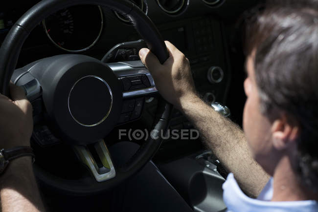 Primer plano del hombre sosteniendo el volante mientras conduce el coche - foto de stock