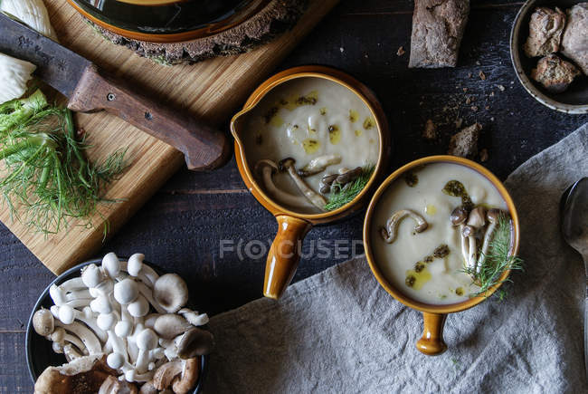 Served in bowls tasty mushroom cream on rustic wooden table with ingredients — Stock Photo