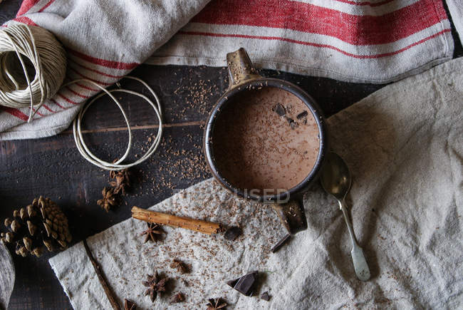 Chocolat chaud à la cannelle dans une tasse sur fond rustique — Photo de stock