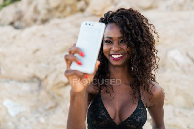 Fröhliche hübsche schwarze Frau macht Selfie draußen — Stockfoto
