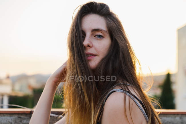 Щаслива молода жінка з довгим волоссям позує на відкритому повітрі — стокове фото