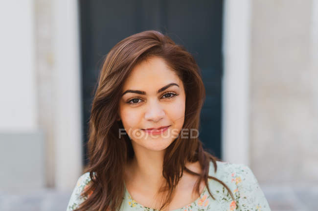 Portrait of pretty young woman looking at camera on street — Stock Photo