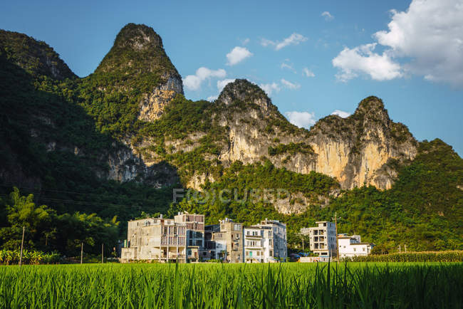 Risaia e gli edifici della piccola città cinese in montagna, Guangxi, Cina — Foto stock