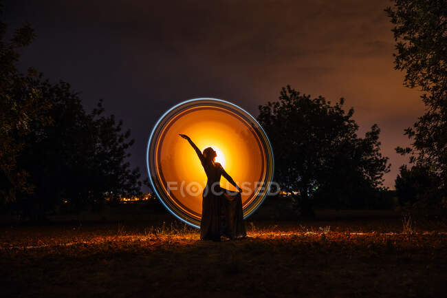 Female silhouette in glowing circle in nature — Stock Photo