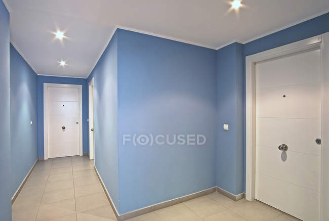 Weiße Türen im modernen blauen Korridor — Stockfoto