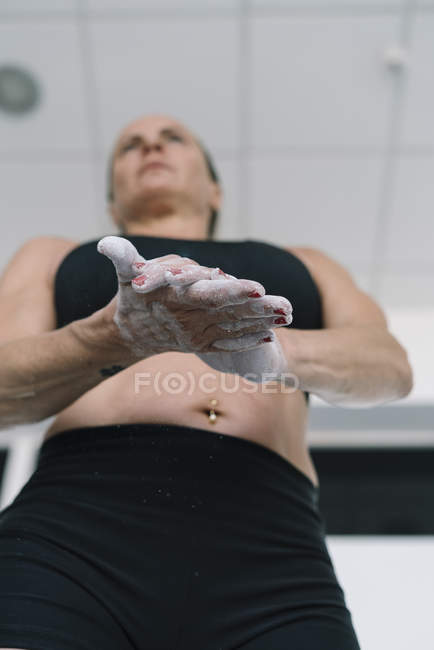 Donna gesso diffusione sulle mani durante l'allenamento in palestra — Foto stock