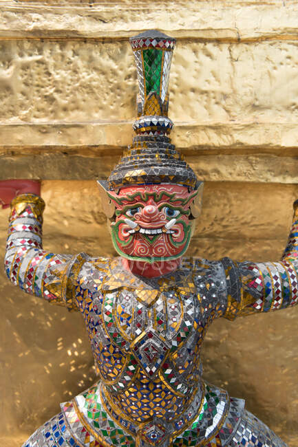Coloridas estatuas históricas tradicionales que sostienen la pared en Palace Real, Bangkok, Tailandia. - foto de stock