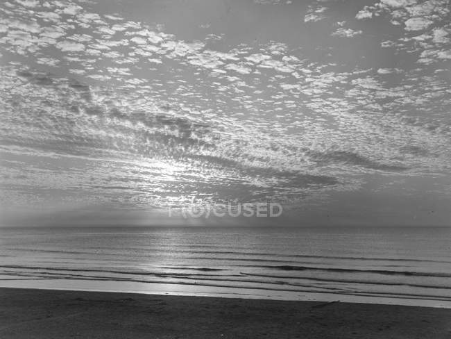 Живописный вид на песчаное побережье и облачное небо — стоковое фото