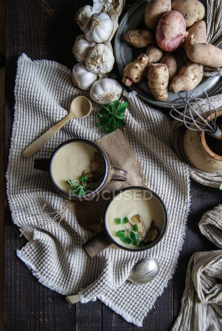 Bol de soupe d'artichaut Jérusalem savoureuse avec des ingrédients sur une table en bois rustique — Photo de stock