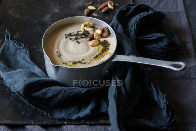 Сливочный суп из цветной капусты с миндалем в кастрюле на подносе с тканью — стоковое фото