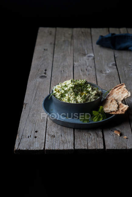 Delicious tzatziki appetizer served with pita in bowl on wooden table — Stock Photo