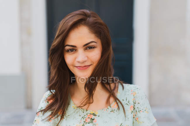 Sorrindo jovem mulher olhando para a câmera na rua — Fotografia de Stock