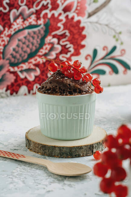 Torta tazza, forno a microonde, pronta in 2 minuti. deliziosa mini torta al cioccolato con ribes in piccola ciotola blu — Foto stock