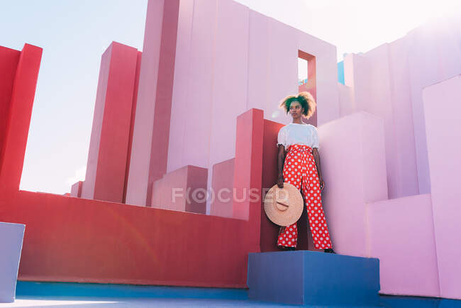 Black woman standing in a colorful geometric building roof terrace — Stock Photo