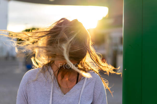 Allegra giovane donna in luce del tramonto capelli in movimento — Foto stock