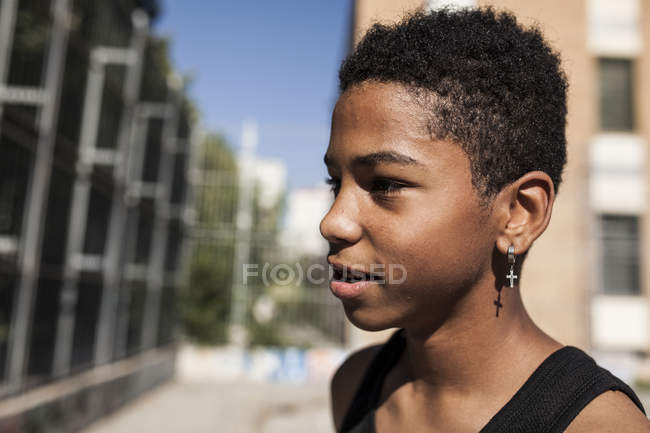 Portrait de jeune garçon afro avec boucle d'oreille debout à l'extérieur — Photo de stock