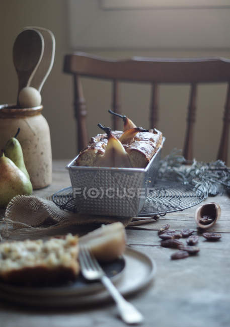 Freshly baked delicious pear pie in baking dish on wooden table — Stock Photo