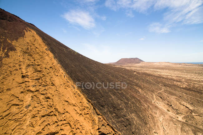 Colinas estéreis laranja e montanhas com planícies, La Graciosa, Ilhas Canárias — Fotografia de Stock