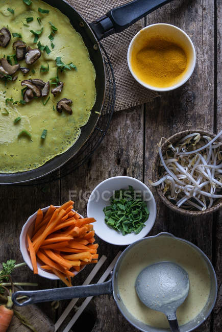 Frying pan with green crepe of Banh Xeo with fresh vegetables in process of cooking — Stock Photo