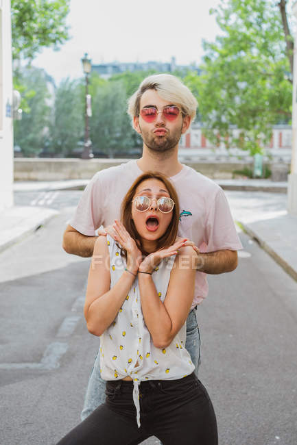 Male and female friends in sunglasses posing on street — Stock Photo