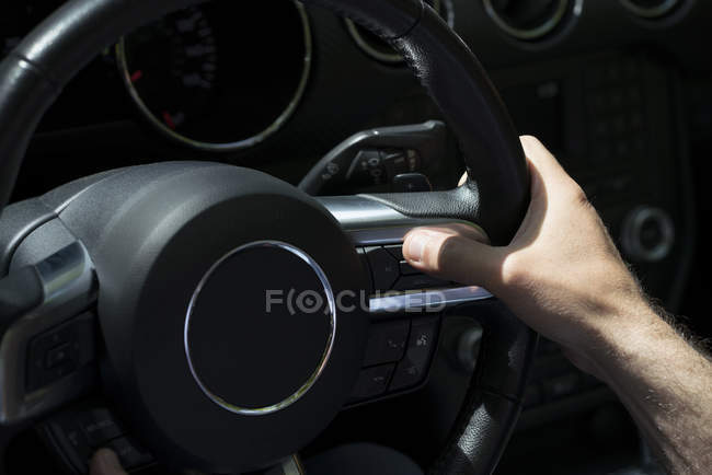Крупным планом мужской руки на руле в автомобиле — стоковое фото