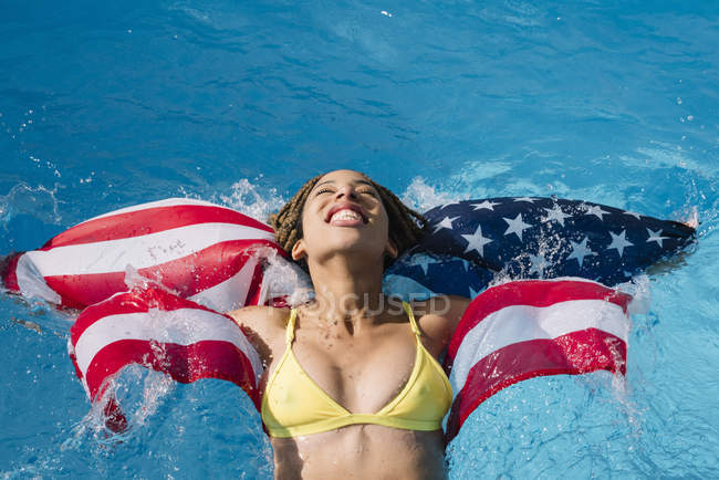 Щасливі жінка весело у басейну з американським прапором — стокове фото