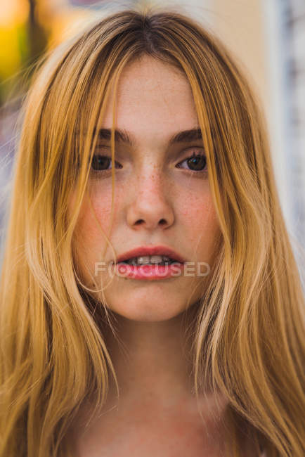 Nahaufnahme einer blonden jungen Frau, die im Freien in die Kamera schaut — Stockfoto