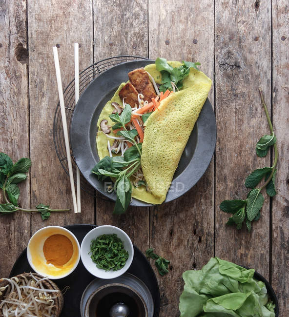 Panqueca frita salgada vietnamita com legumes e ingredientes na mesa de madeira — Fotografia de Stock