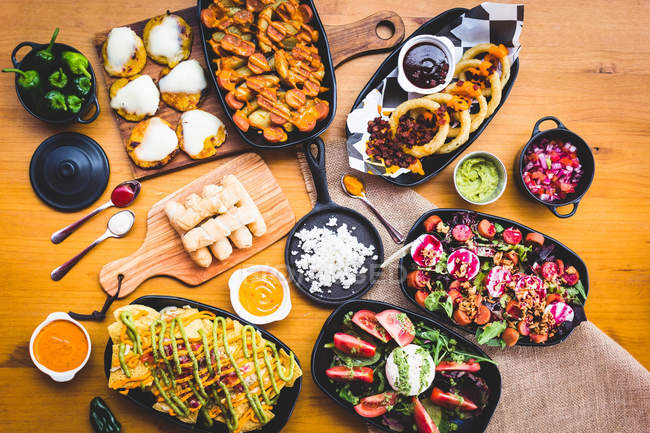 Snacks e pratos servidos na mesa de madeira — Fotografia de Stock