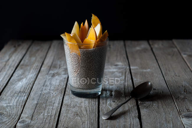 Вкусный пудинг чиа с манго в стекле на деревянном столе — стоковое фото