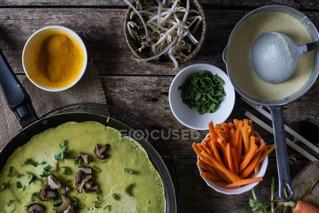 Frigideira com crepe verde de Banh Xeo com legumes frescos em processo de cozimento — Fotografia de Stock