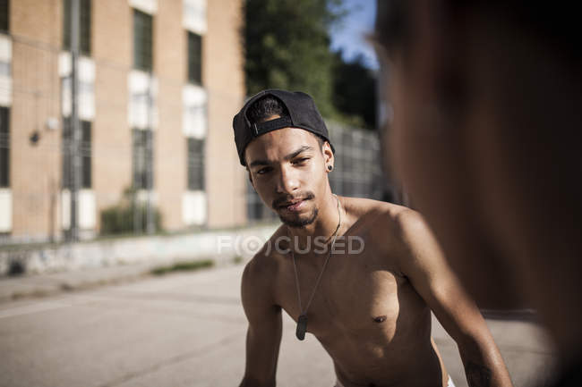 Без рубашки африканский мальчик стоит на улице против здания — стоковое фото