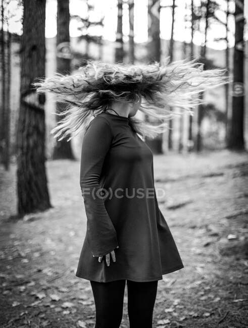 Bianco e nero a testa in giù colpo di donna irriconoscibile in piedi in legno chiaro e scuotendo i capelli — Foto stock