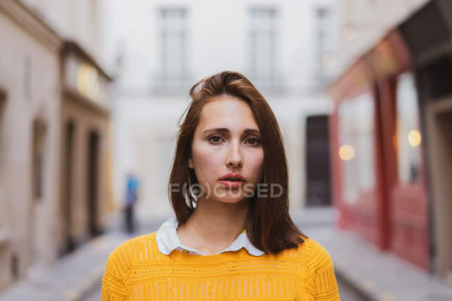 Ritratto di una giovane donna seria che guarda la macchina fotografica sulla strada — Foto stock
