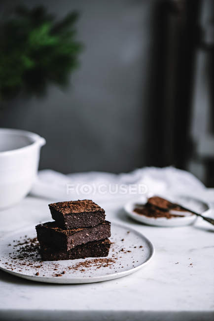 Scheiben veganen Brownie auf Teller auf weißer Tischplatte — Stockfoto