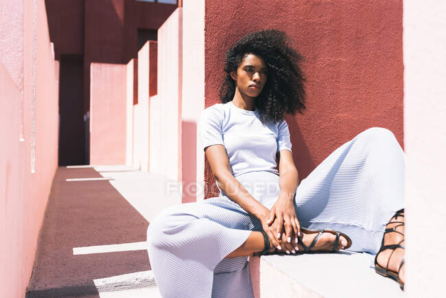 Черная женщина сидит в красочном геометрическом здании — стоковое фото