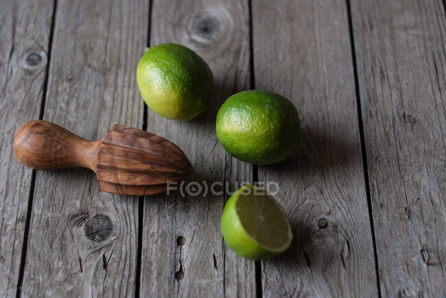 Limas deliciosas com espremedor manual de citrinos — Fotografia de Stock