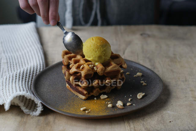 Waffles mão humana verificação com banana e sorvete de caril com colher — Fotografia de Stock