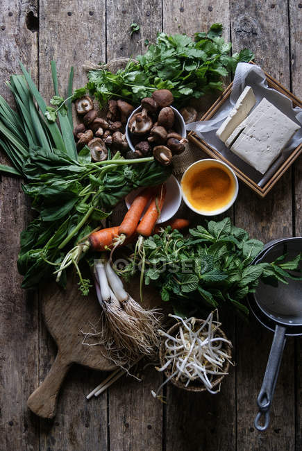 Arrangiertes Gemüse auf rustikalem Tisch zur Zubereitung traditioneller Crepe Banh xeo — Stockfoto