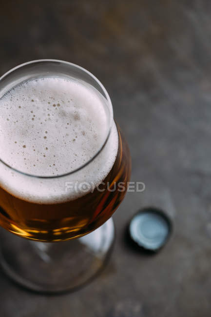 Primer plano del vaso de cerveza sobre fondo gris - foto de stock