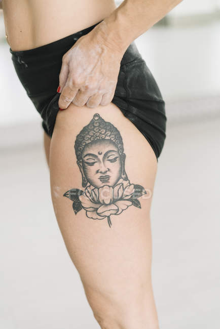 Close-up of female athlete showing Buddha tattoo on leg — muscular, woman -  Stock Photo | #216970400