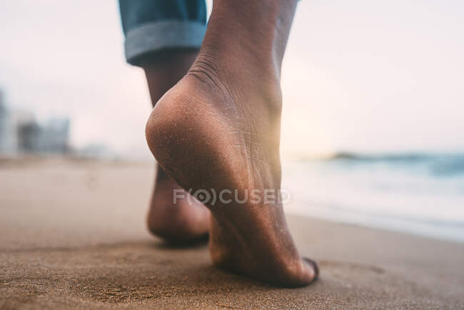 Mujer caminando en la playa descalza - foto de stock