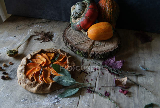 Leckere gebackene Kürbisgalette mit süßen Zwiebeln auf rustikalem Holztisch — Stockfoto