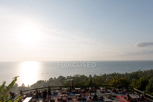 Vista sul mare nella giornata di sole e persone che cenano sulla terrazza sull'isola di Koh Phangan, Thailandia. — Foto stock