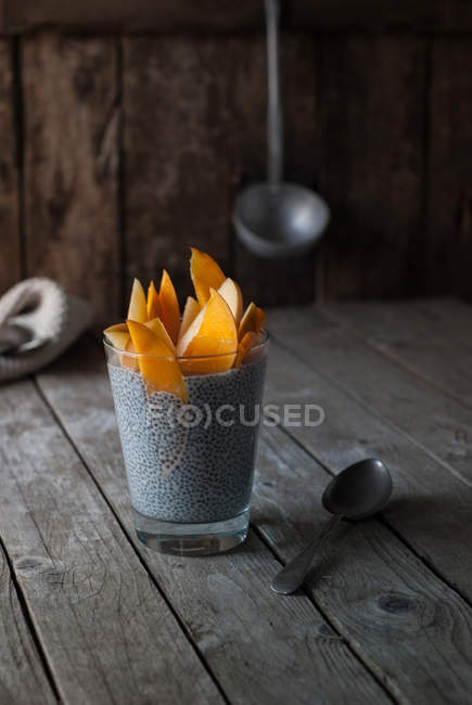 Pudim de chia delicioso com manga em vidro na mesa de madeira — Fotografia de Stock