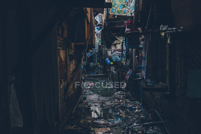 Vista da rua suja e grungy estreita inundada com água e lixo flutuando no topo — Fotografia de Stock