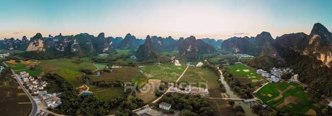 Campos y ciudad rodeada de montañas, Guangxi, China - foto de stock