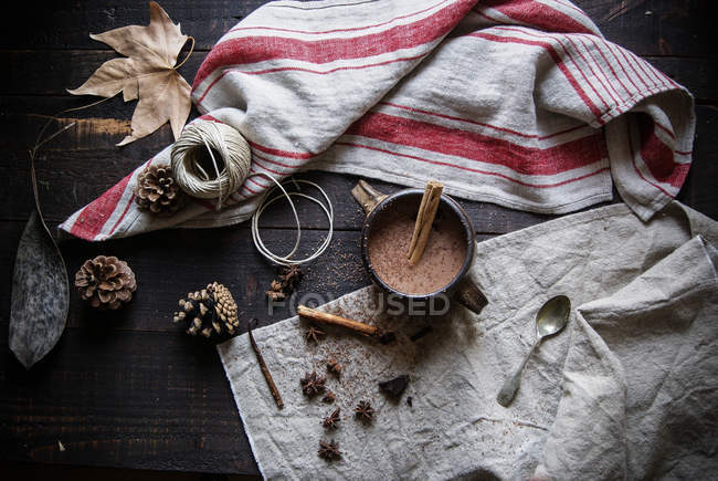 Горячий шоколад с корицей в кружке на деревенском фоне — стоковое фото