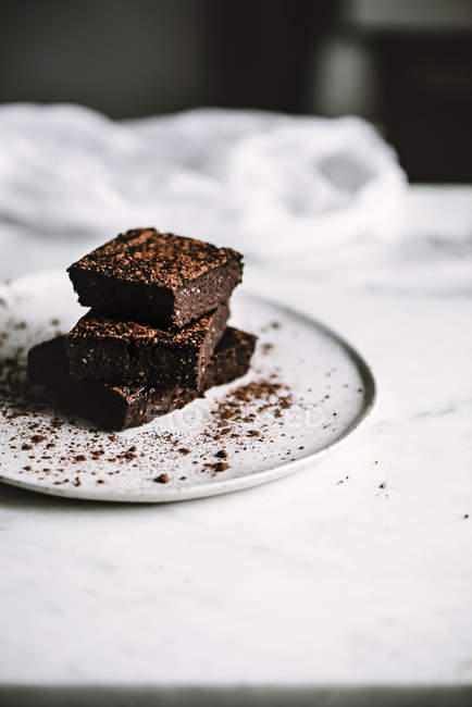 Fatias vegan brownie na placa na mesa branca — Fotografia de Stock
